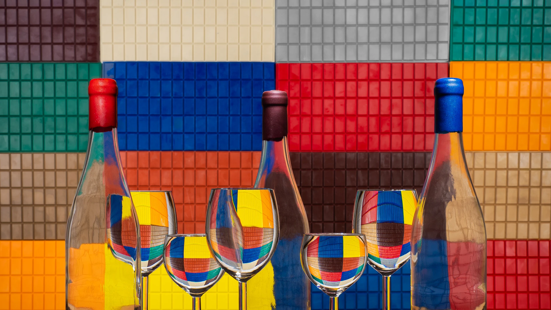 Bannière Laffitte Liège : bouteilles cachetées devant le mur de tablettes de cire colorées